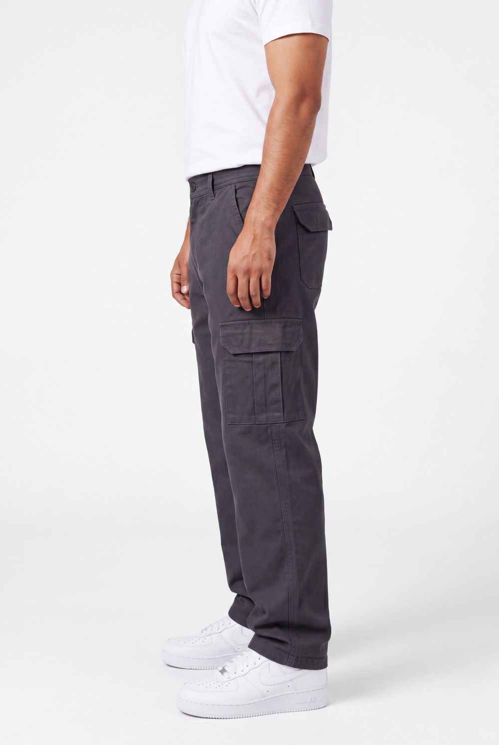 Person wearing gray cargo pants on a white background