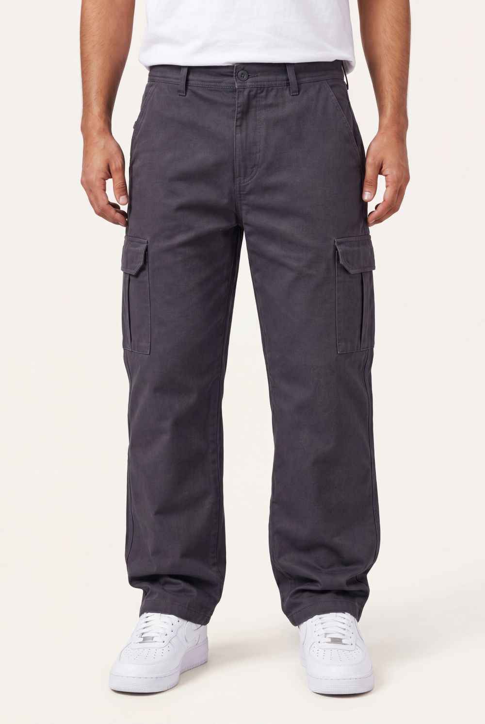 Person wearing dark gray cargo pants on a white background